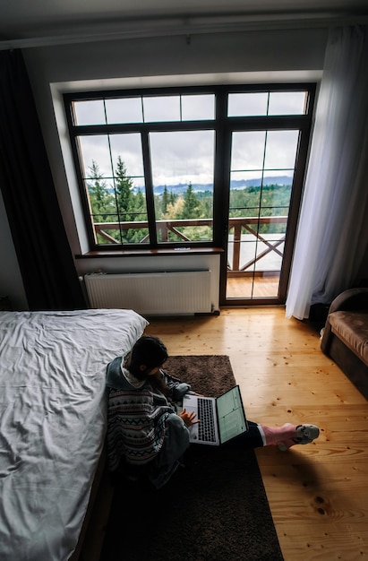 Foto femmina con laptop seduto sul pavimento e lavorando sul laptop