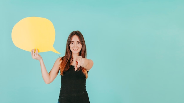 Female with speech bubble pointing at camera