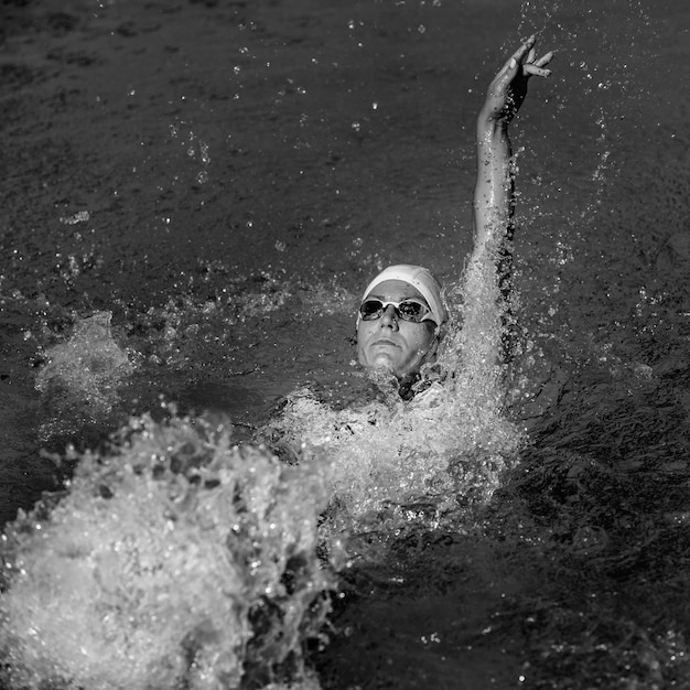 Female with tattoos swimming backstroke on training