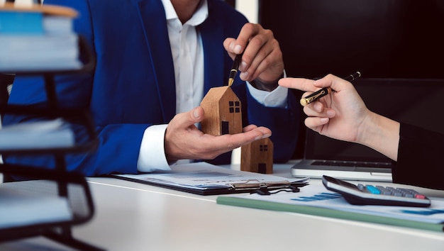 Female woman hands holding home model small miniature white toy house Mortgage property insurance dream moving home and real estate concept