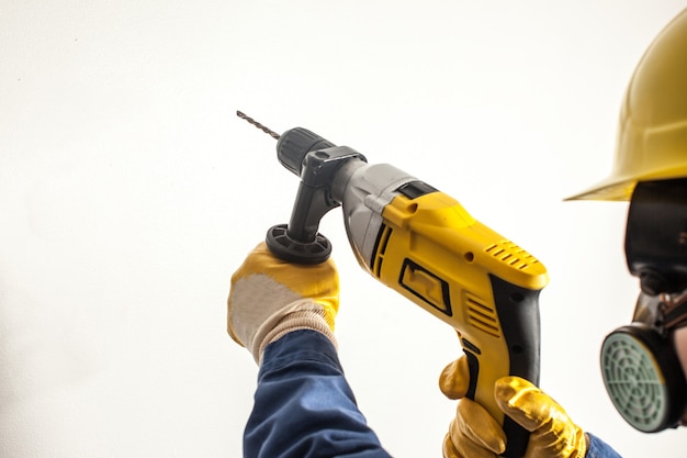 Female worker drills the wall, hard work for women