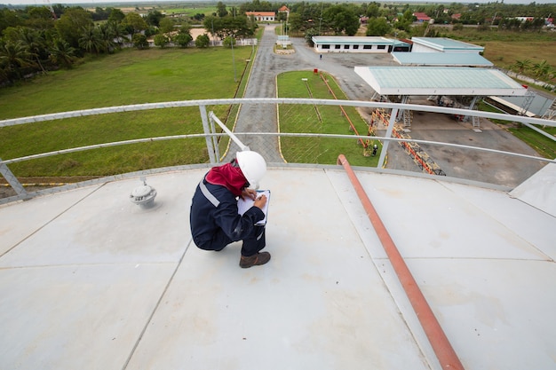 Female worker inspection visual roof storage tank oil