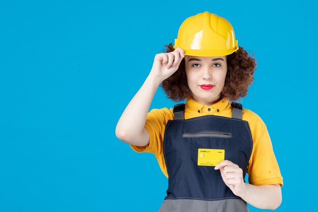 Female worker in uniform with credit card on blue