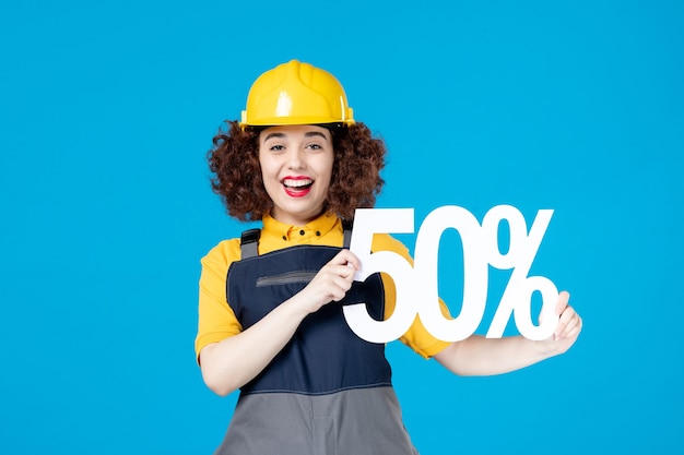 Female worker in uniform with sign on blue