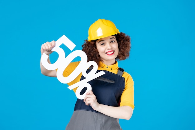 Female worker in uniform with sign on blue