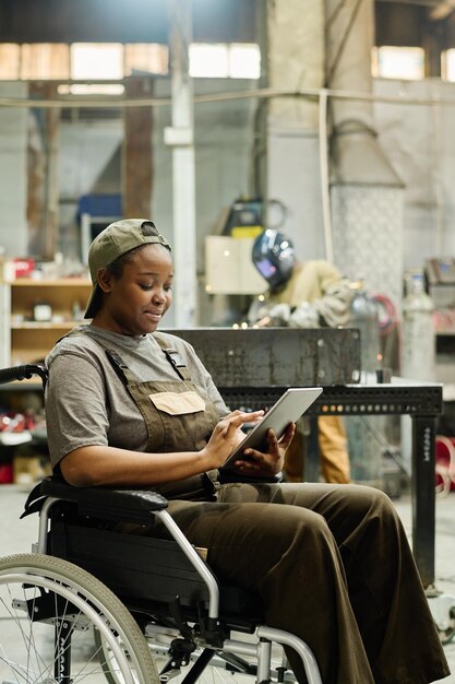 Photo female worker in wheelchair in workshop