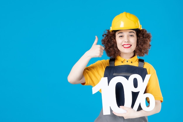 Female worker in yellow uniform and helmet on blue