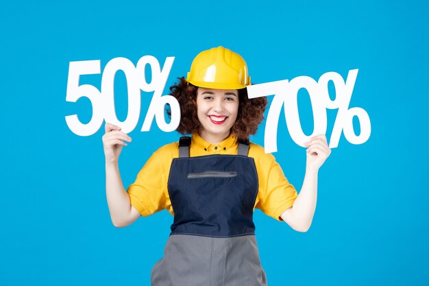 Female worker in yellow uniform with and signs on blue