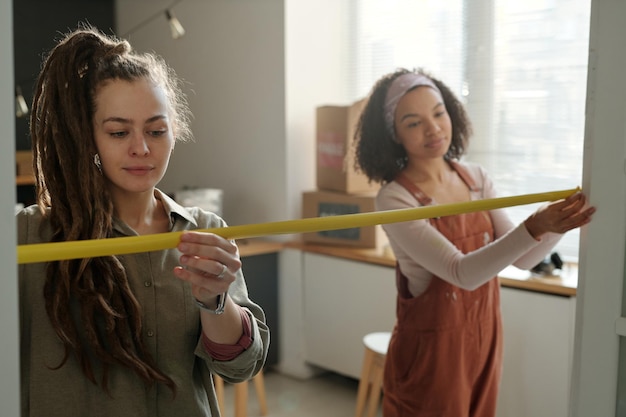 Female workers measuring doorway width