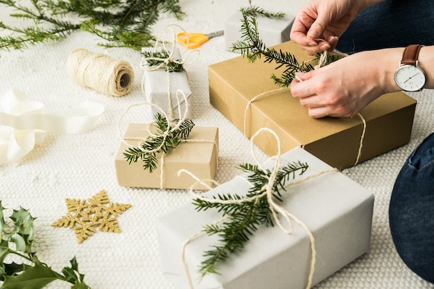 Female wrapping a Christmas present in natural vintage paper