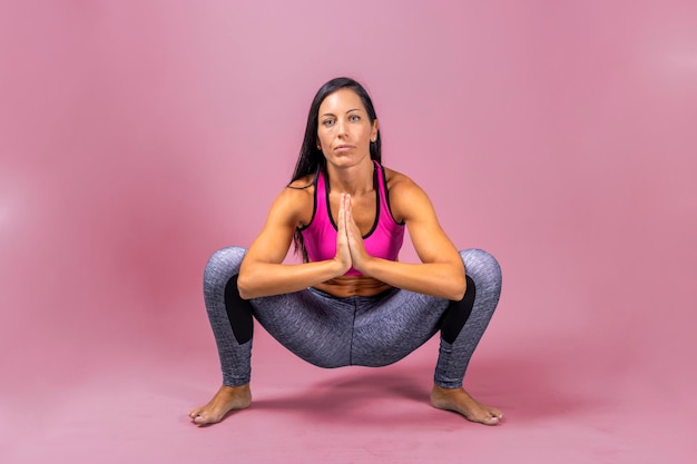 Женщина-инструктор по йоге делает упражнения на полу в спортивной одежде
