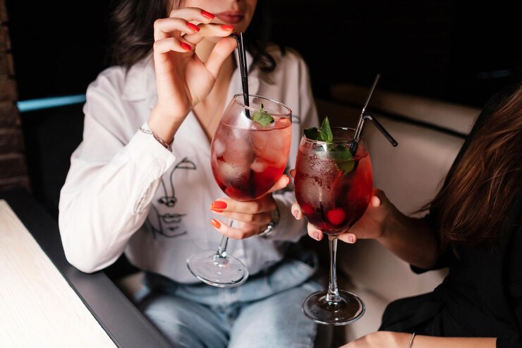 カクテルとチリンとガラスを保持している女性休日のお祝いのナイトライフと人々の概念