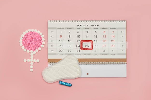 Photo females symbol made of tablets and menstrual calendar female period days or menstrual cycle concept