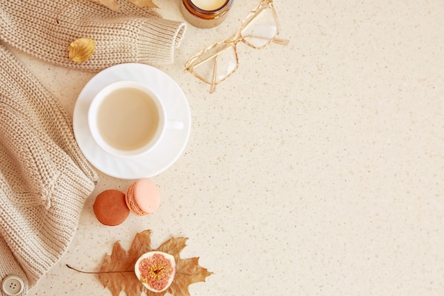 Abito femminile autunnale maglione casual glasess tra tazza di caffè foglie cadute amaretti e fichi copia spazio