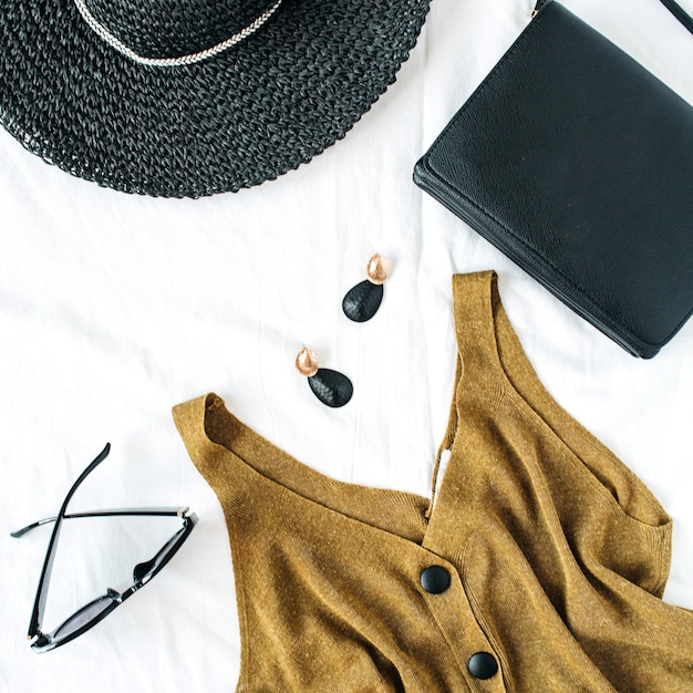 Feminine fashion composition with hat, blouse, earrings, purse, sunglasses on white