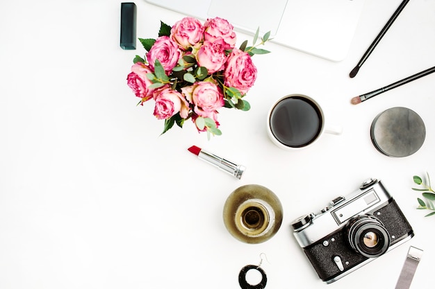 장미 꽃 꽃다발, 빈티지 사진 카메라, 커피 컵 및 흰색 배경에 액세서리가있는 여성스러운 평면 평신도, 상위 뷰 작업 공간