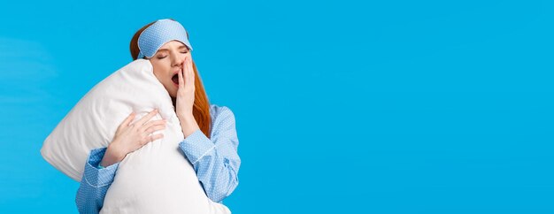 Foto adolescente dai capelli rossi adorabile femminile e glamour che sbadiglia e copre la bocca aperta sentendosi assonnato e stanco