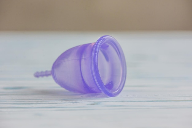 Feminine hygiene product - Menstrual cup On a wooden background