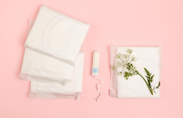 Feminine sanitary pads and tampon on a pink background