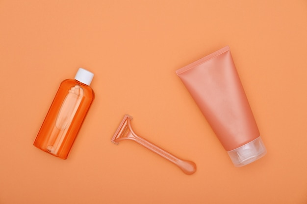 Feminine shaving set on orange paper