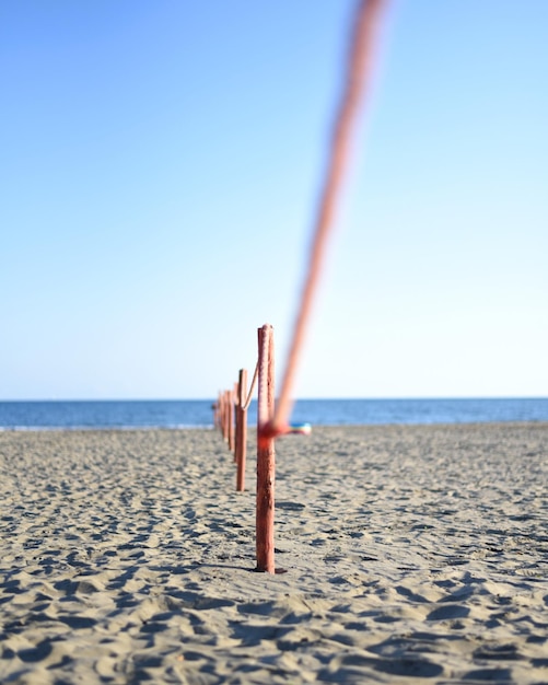 Photo fence at beach against clear blue sky