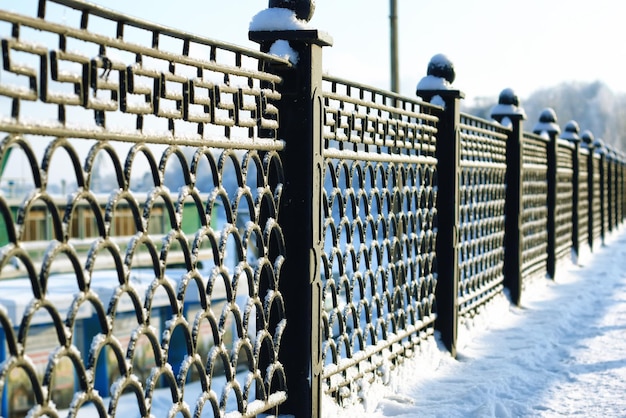 Fence covered snow winter park