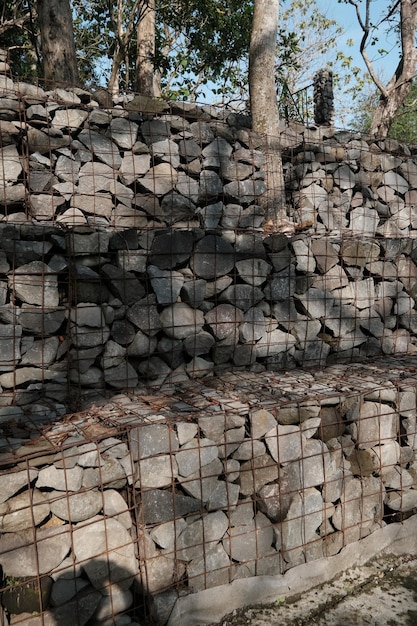 A fence is next to a pile of rocks.