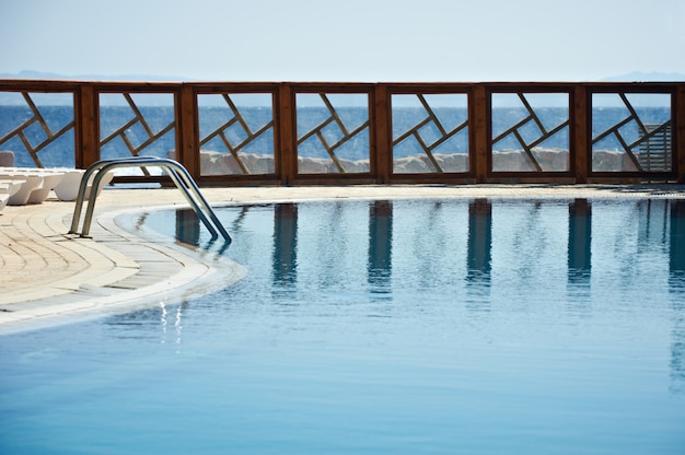 Foto recinto della piscina del resort riflessa sull'acqua.