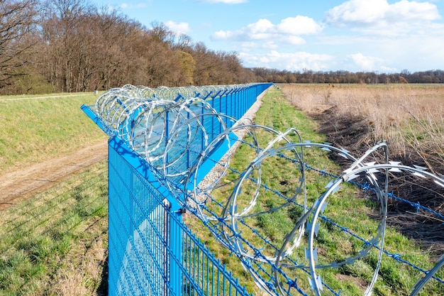 Fence with barbed wire at a guarded facility it is dangerous to enter