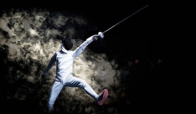 The fencer moves forward with a sword in his hand. Sport concept. Mixed media