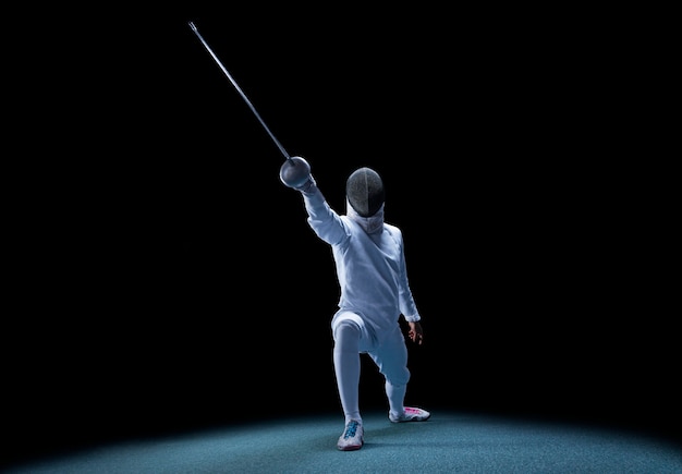 Foto fencer avanza con una spada in mano