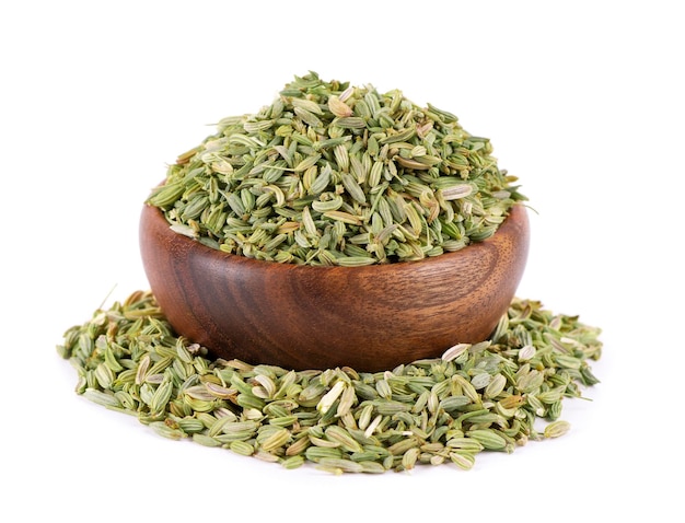 Fennel seeds in wooden bowl isolated on white background Green fennel grains Spices and herbs