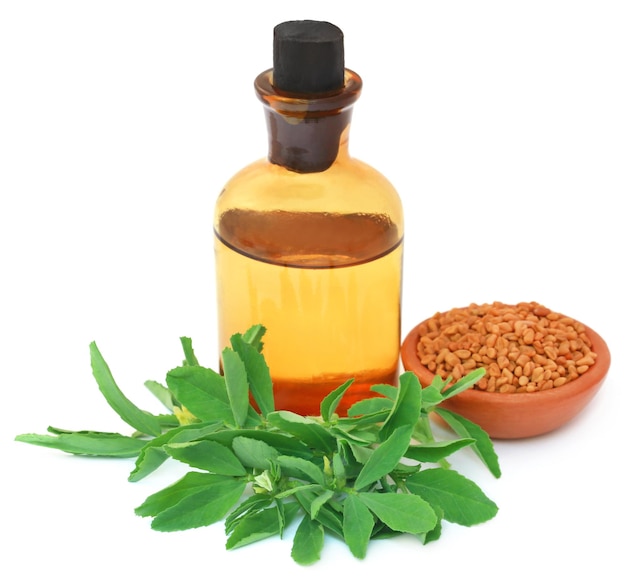 Photo fenugreek leaves with seeds and oil in a bottle