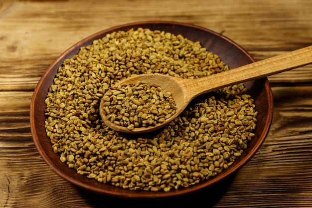 Photo fenugreek seeds in ceramic plate on wooden table