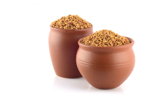 Fenugreek seeds in clay pot isolated