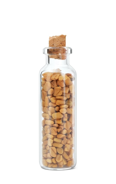 Fenugreek seeds in glass bottle on white background