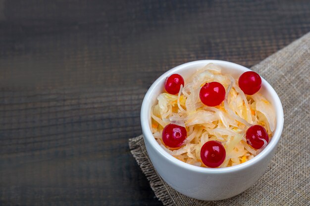 fermented cabbage with cranberries in a bowl on rustic wooden table