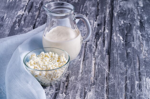 Fermented drink kefir in a glass and curd cheese in glass bowl.