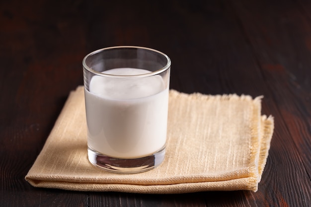 Fermented drink kefir in a glass on wooden background