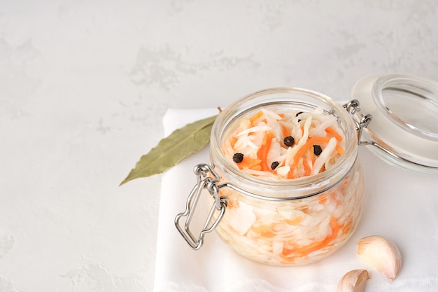 Fermented food. Sauerkraut with black pepper in a glass bowl on gray