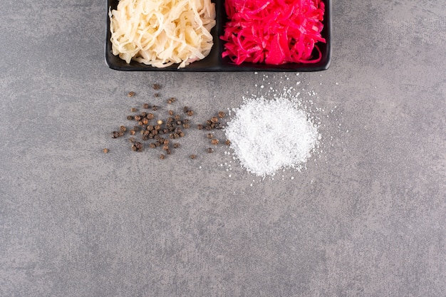 Fermented vegetables sauerkraut placed on stone table.