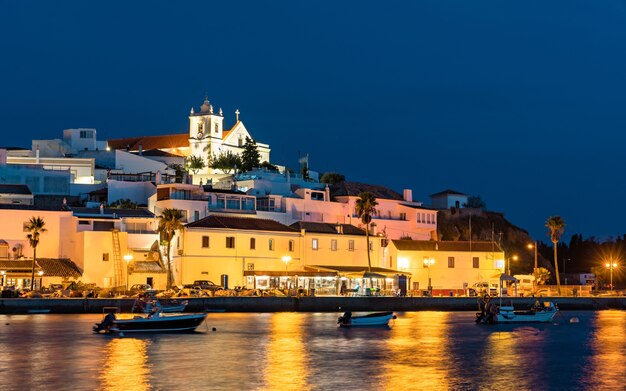 Ferragudo village with fishing boats at sunset in Portugal