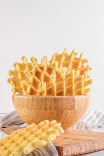 Ferratelle of pizzelle een traditioneel dessert of koekjes uit Abruzzo in een kom op witte houten achtergrond kopie ruimte