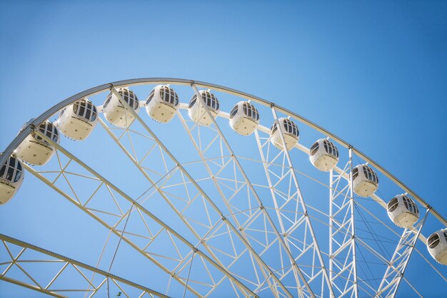 Ferris wheel against the blue sky closeup