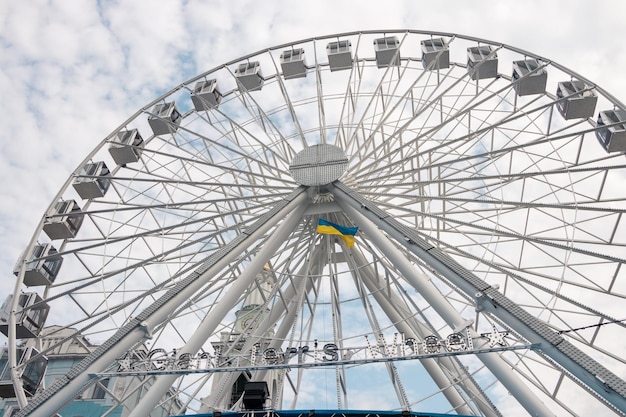 Ferris wheel on the background of fluffy clouds