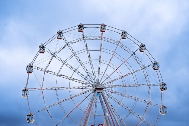 Ferris wheel in the blue sky glows for evening riding