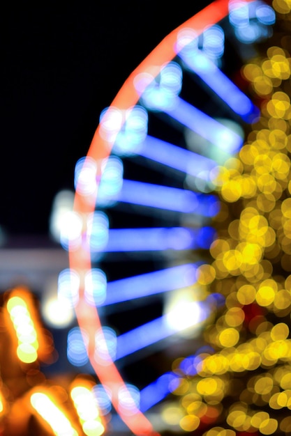 Ferris wheel decorated blue illumination and large Christmas tree