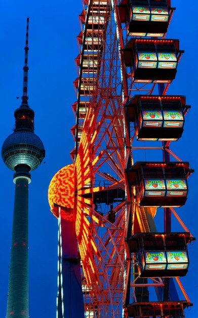 Ferris Wheel of Night Christmas Market at Town Hall in Winter Berlin, Germany. German street Xmas and holiday fair in European city or town. Advent Decoration and Stalls with Crafts Items on Bazaar
