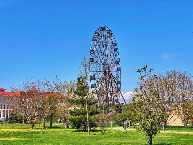 Ferris wheel in park against blue sky