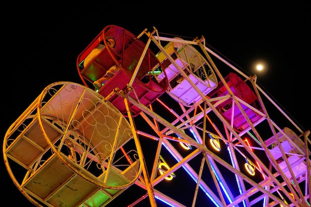 La ruota panoramica gira intorno al carnevale nella notte del fullmoon.